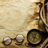 Компас и очки на пергаменте